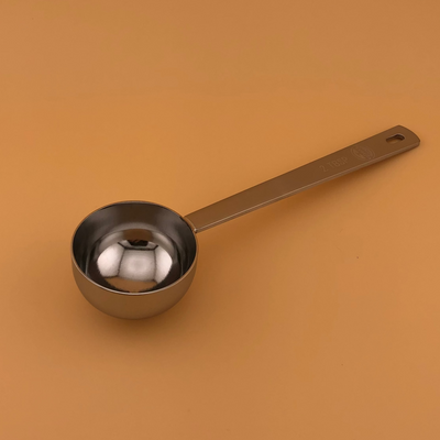 Metal measuring spoon on a brown background